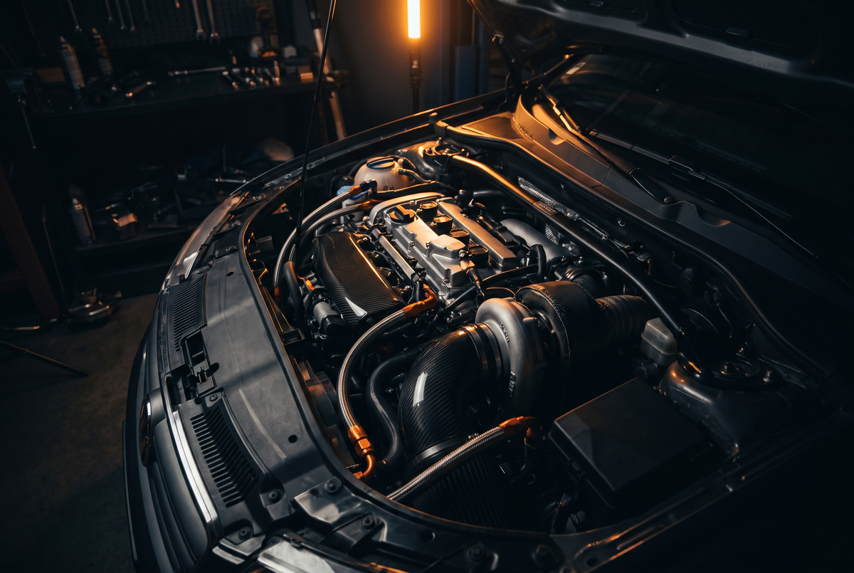 Open bonnet showing a turbocharged performance engine bay with carbon fibre covers
